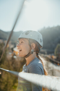 Girl ziplining in sunshine, big smile