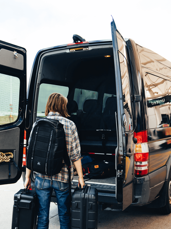 Passenger loading a sprinter van with luggage